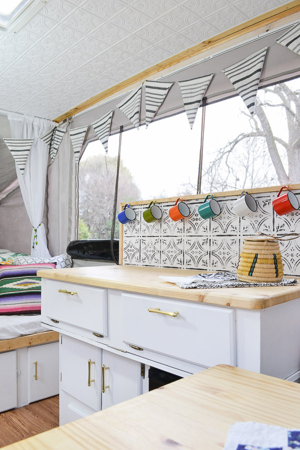 pop up camper with white cabinets and wood countertops 
