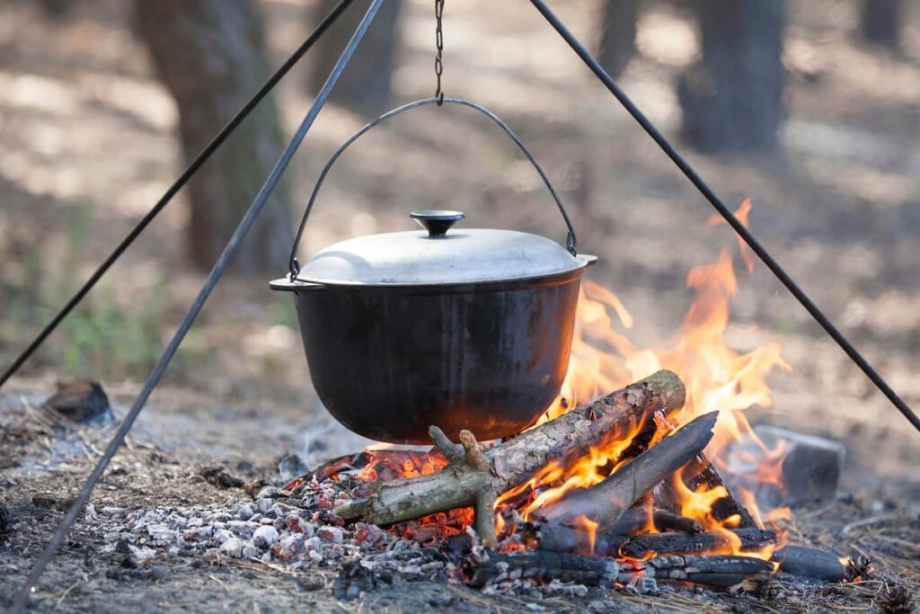 cast iron dutch oven on a tripod over the campfire for cast iron camping cooking