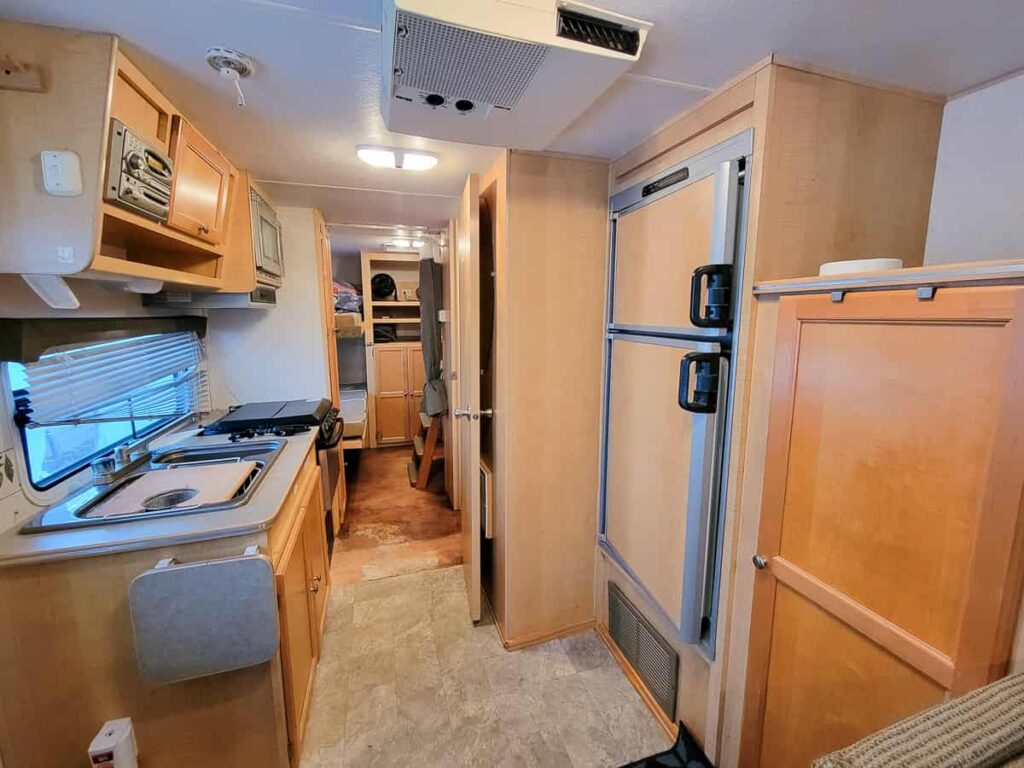 kitchen of hybrid camper with fridge, freezer, sink, stove, microwave