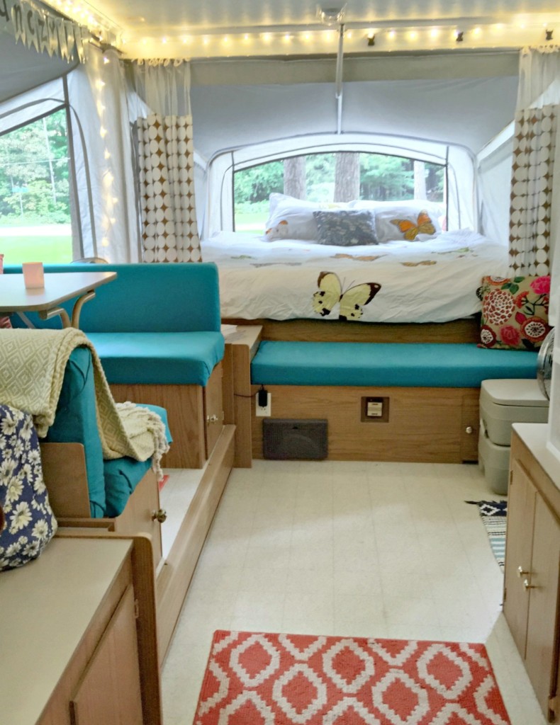 camper remodel with teal cushions and indoor fairly lights