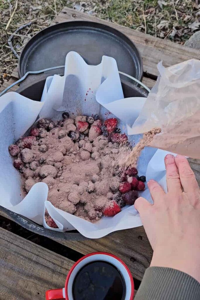 camping chocolate cake with cherries strawberries and blueberries cooked over the campfire