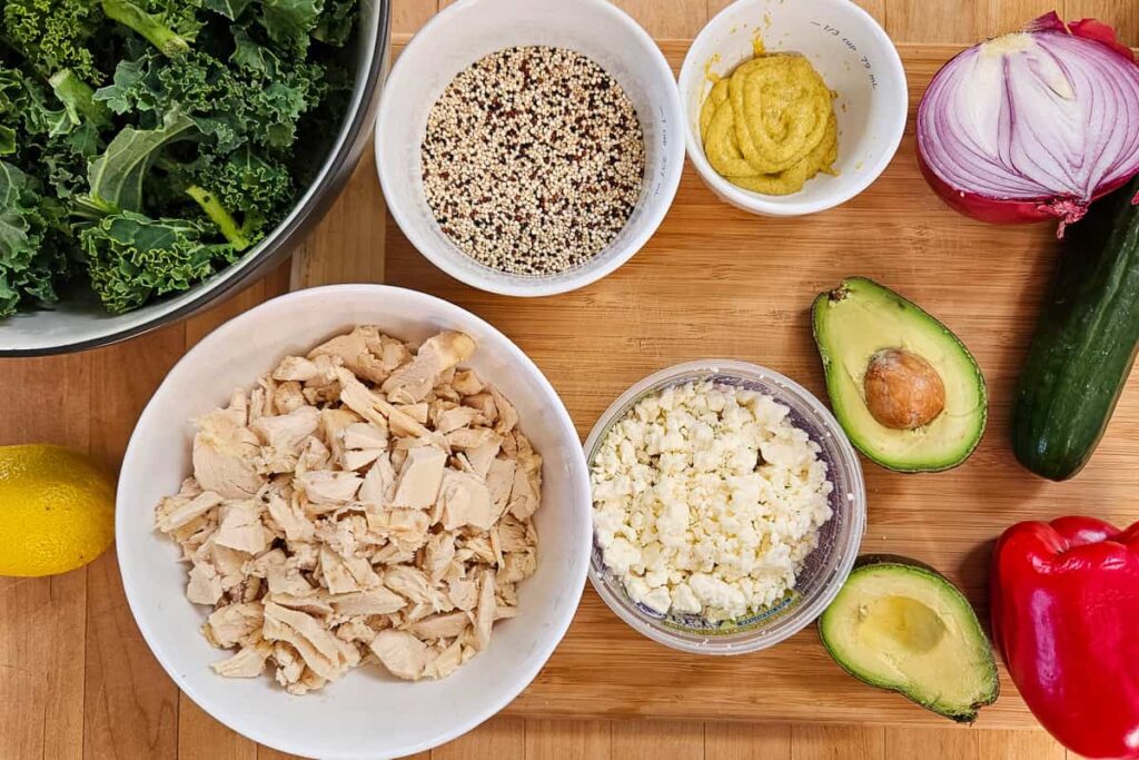 ingredients for kale quinoa salad with chicken, pepper, onion, avocado and homemade lemon dijon dressing
