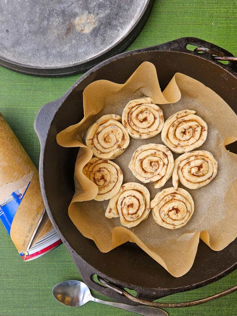 easy campfire cinnamon rolls in a dutch oven over campfire or coals