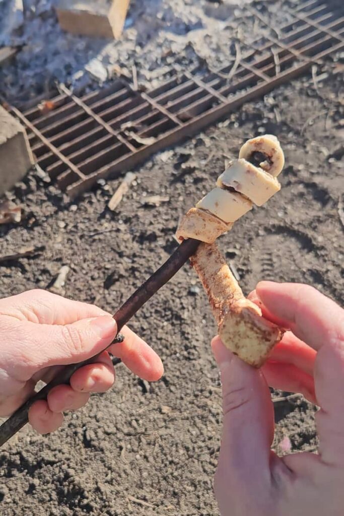 roast a cinnamon roll on a stick for camping dessert