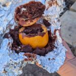 easy camping dessert hack to make cake, muffins and brownies in an orange over the campfire