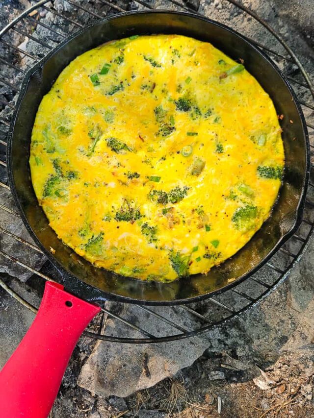 healthy camping breakfast with eggs in a broccoli cheddar cast iron campfire frittata