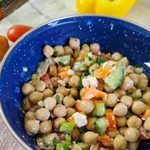 make ahead salad with chick peas, cucumber, tomato, feta, green onion, olives, pepper and dressing