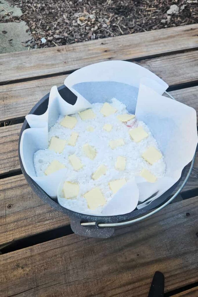 camping dump cake in dutch oven with butter