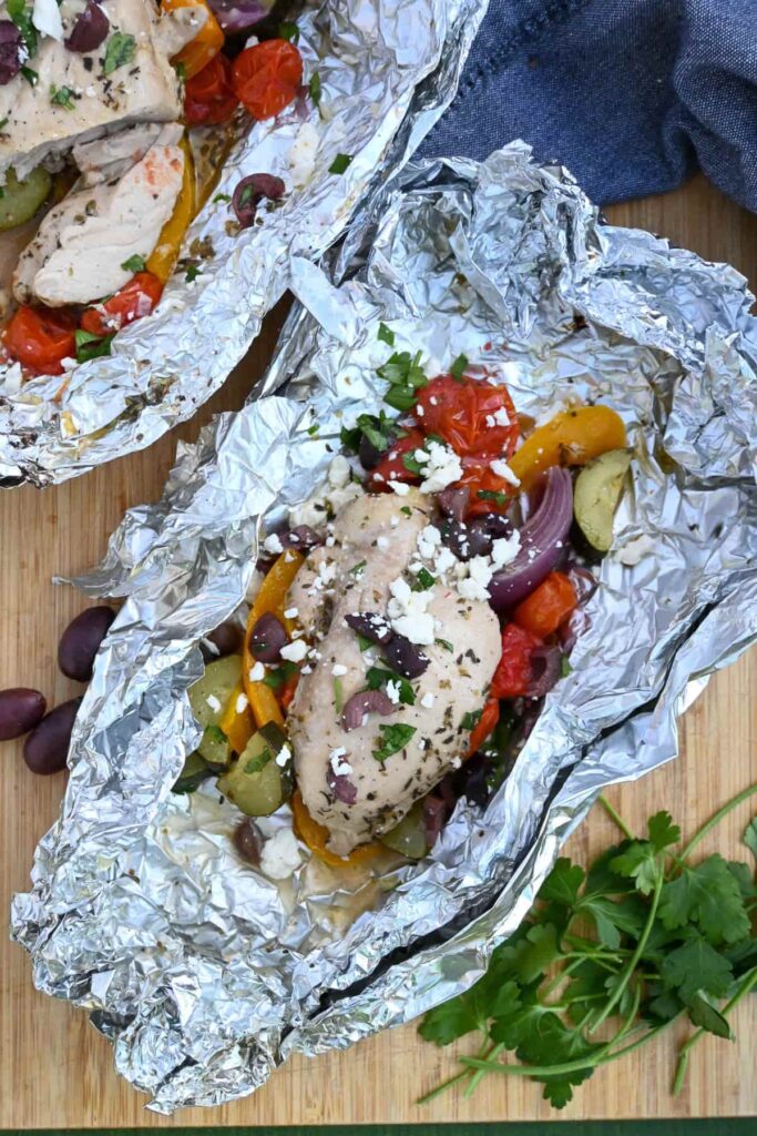 camping food foil packet with chicken and vegetables greek mediterranean flavors cooked over campfire in foil