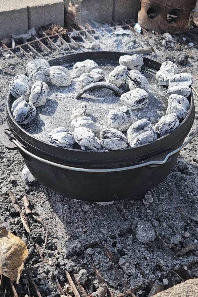 coals on cast iron dutch oven to cook a dump cake