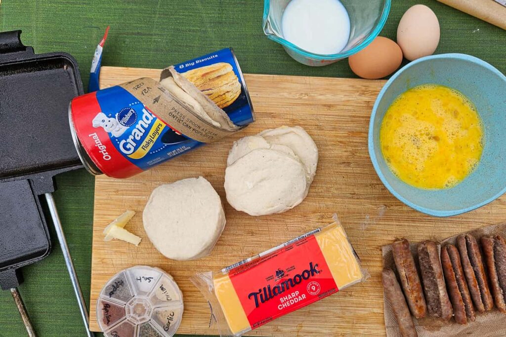 ingredients in hobo pie breakfast sandwiches with sausage biscuit cheese and egg