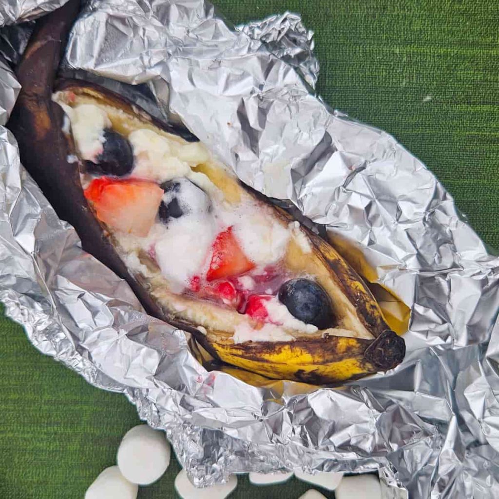 campfire banana boat with strawberries, blueberries, raspberries and cream cheese