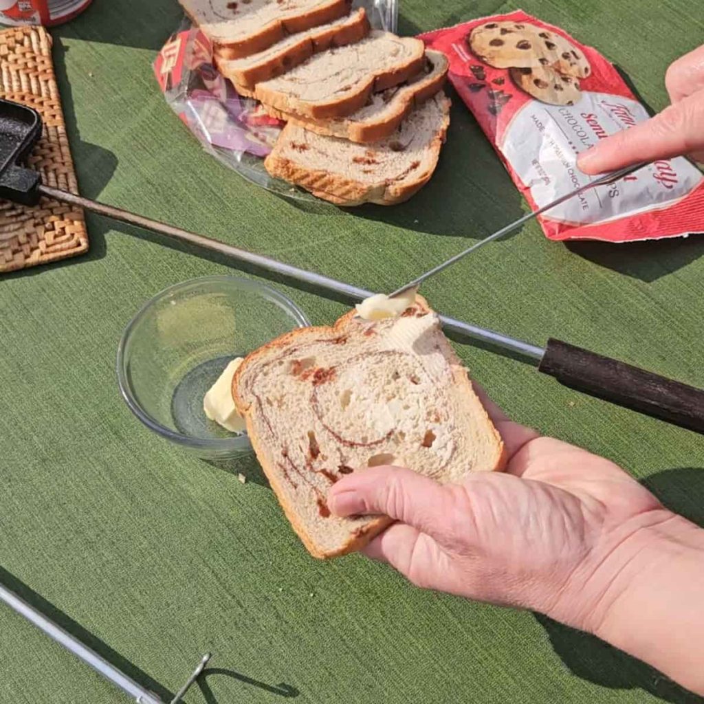 steps to make campfire hobo pie dessert with chocolate and cherries over the campfire in a pie iron