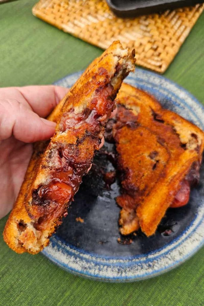 This cherry chocolate pudgy pie cooks up over the campfire in a pie iron and is so easy to make.