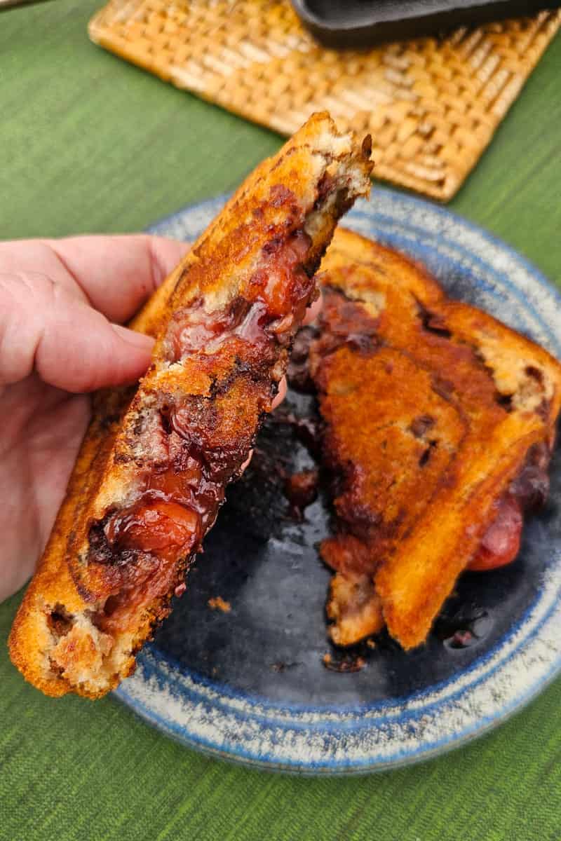 This cherry chocolate pudgy pie cooks up over the campfire in a pie iron and is so easy to make.