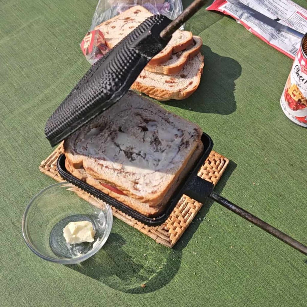 steps to make campfire hobo pie dessert with chocolate and cherries over the campfire in a pie iron