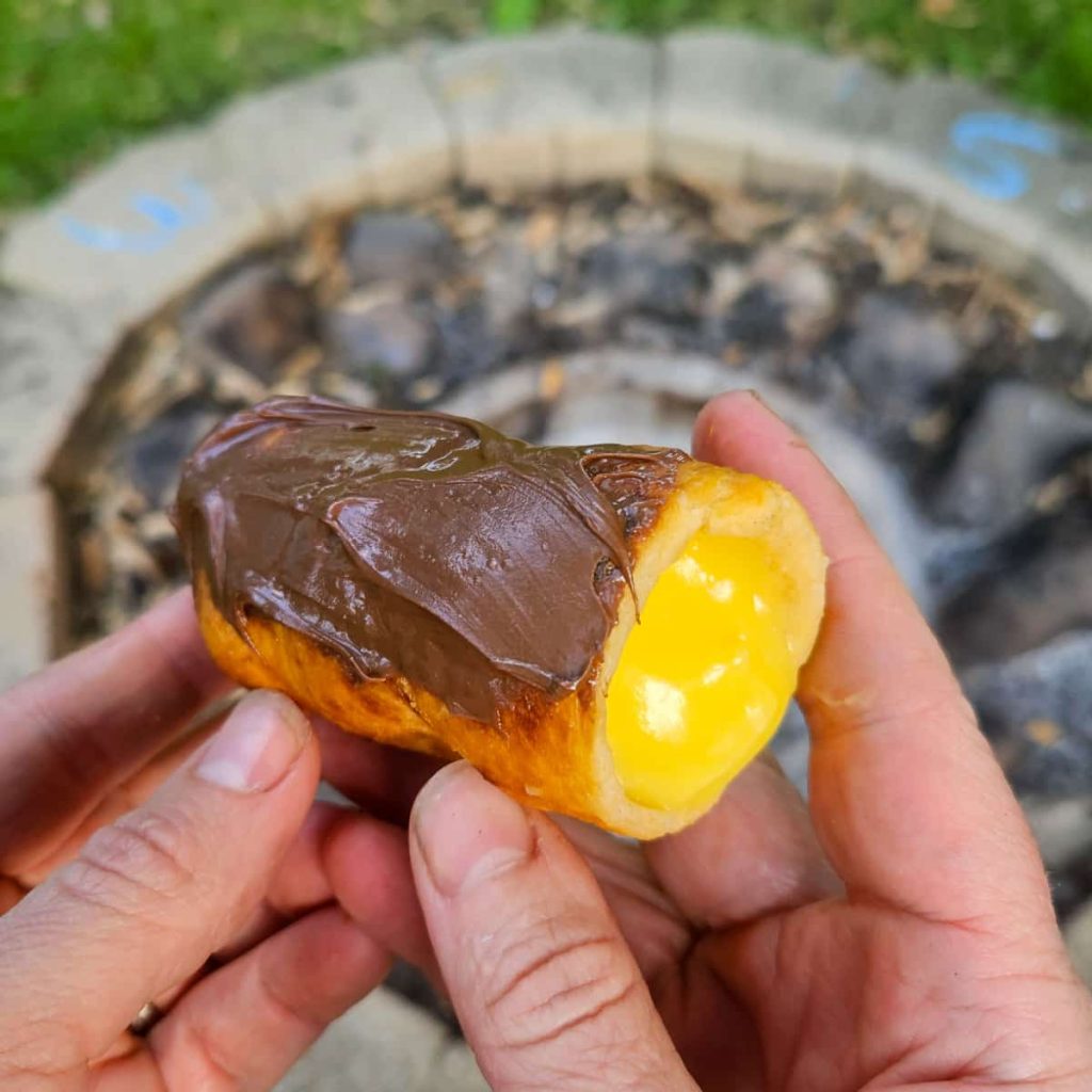 campfire eclairs made by cooking refrigerated dough over the campfire and filling with pudding