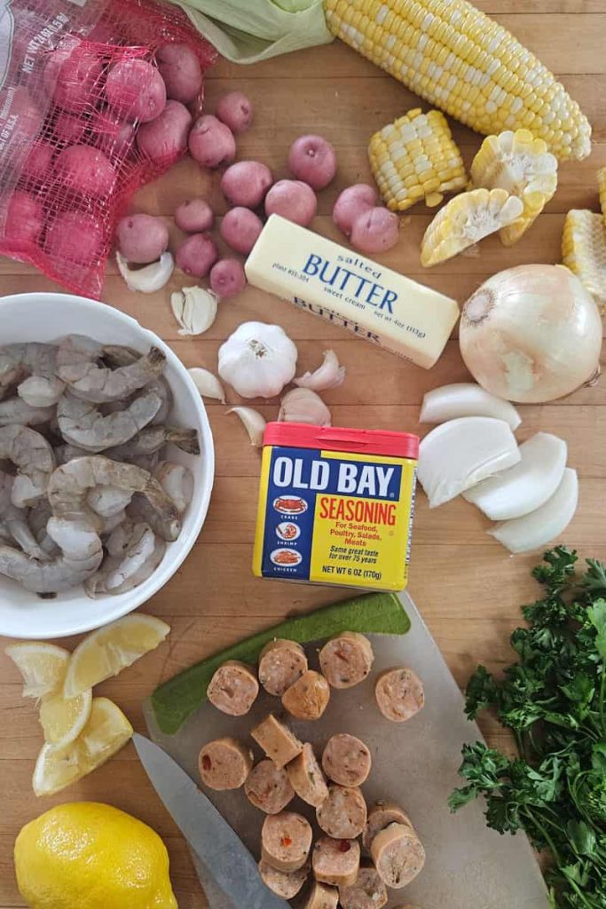 ingredients in cajun shrimp boil foil packets with garlic, Old Bay seasoning, sausage, onions, potatoes, shrimp
