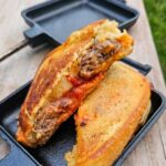 meatball subs in a pie iron with garlic texas toast, cheese and sauce