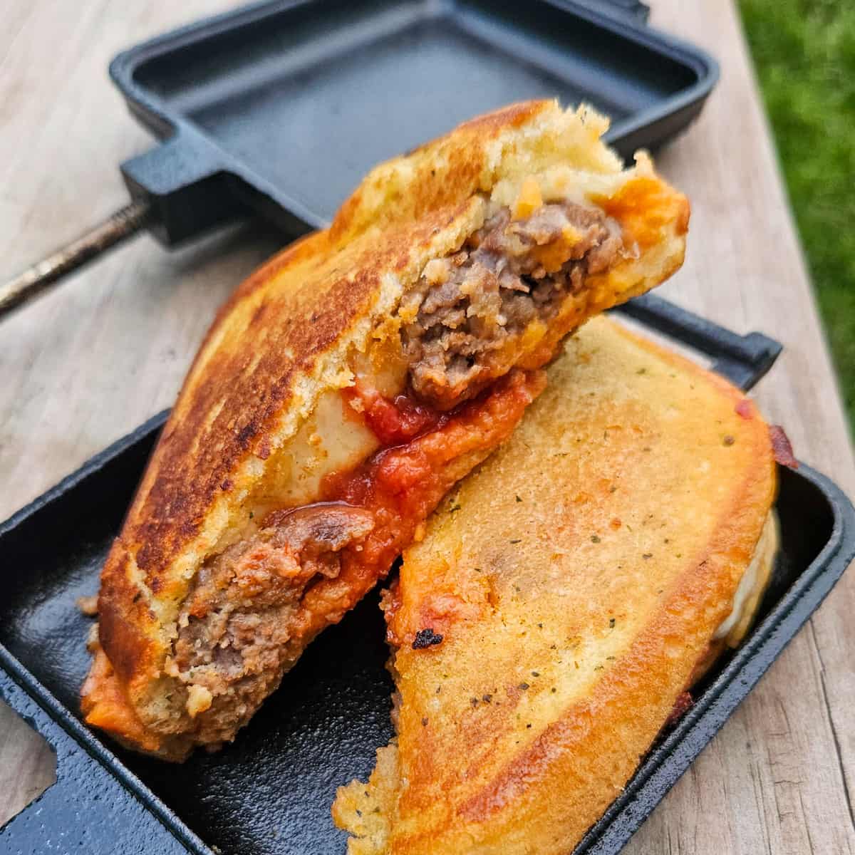 meatball subs in a pie iron with garlic texas toast, cheese and sauce
